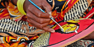 Colorful Indian handicrafts including pottery, textiles, and wooden carvings displayed on a table.