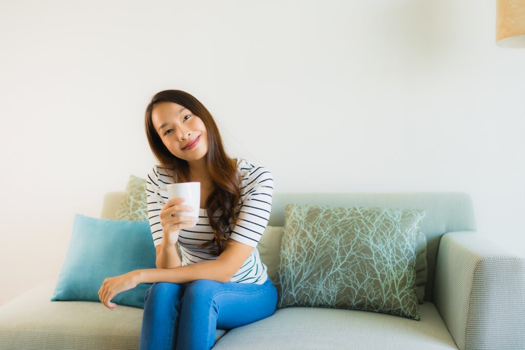 Lifestyle Hacks for Teenagers in India ,Girl sitting on a comfy beanbag chair in a creatively decorated room, smiling and holding a mug of tea.