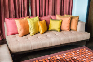 A cozy couch decorated with colorful Indian throws and pillows.