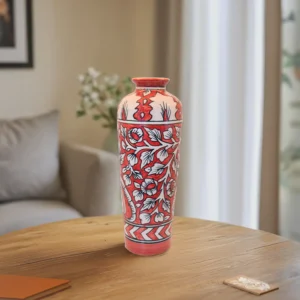 The Crimson Bloom Vase is a true work of art. Its rich red and cream tones, paired with intricate floral patterns, are inspired by timeless traditional Indian designs. Whether placed in a minimalist modern setting or a room filled with vintage décor, this vase stands out beautifully.