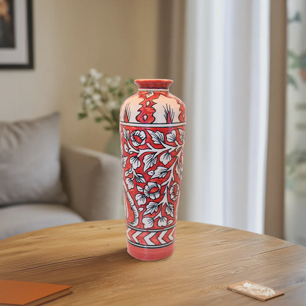 The Crimson Bloom Vase is a true work of art. Its rich red and cream tones, paired with intricate floral patterns, are inspired by timeless traditional Indian designs. Whether placed in a minimalist modern setting or a room filled with vintage décor, this vase stands out beautifully.